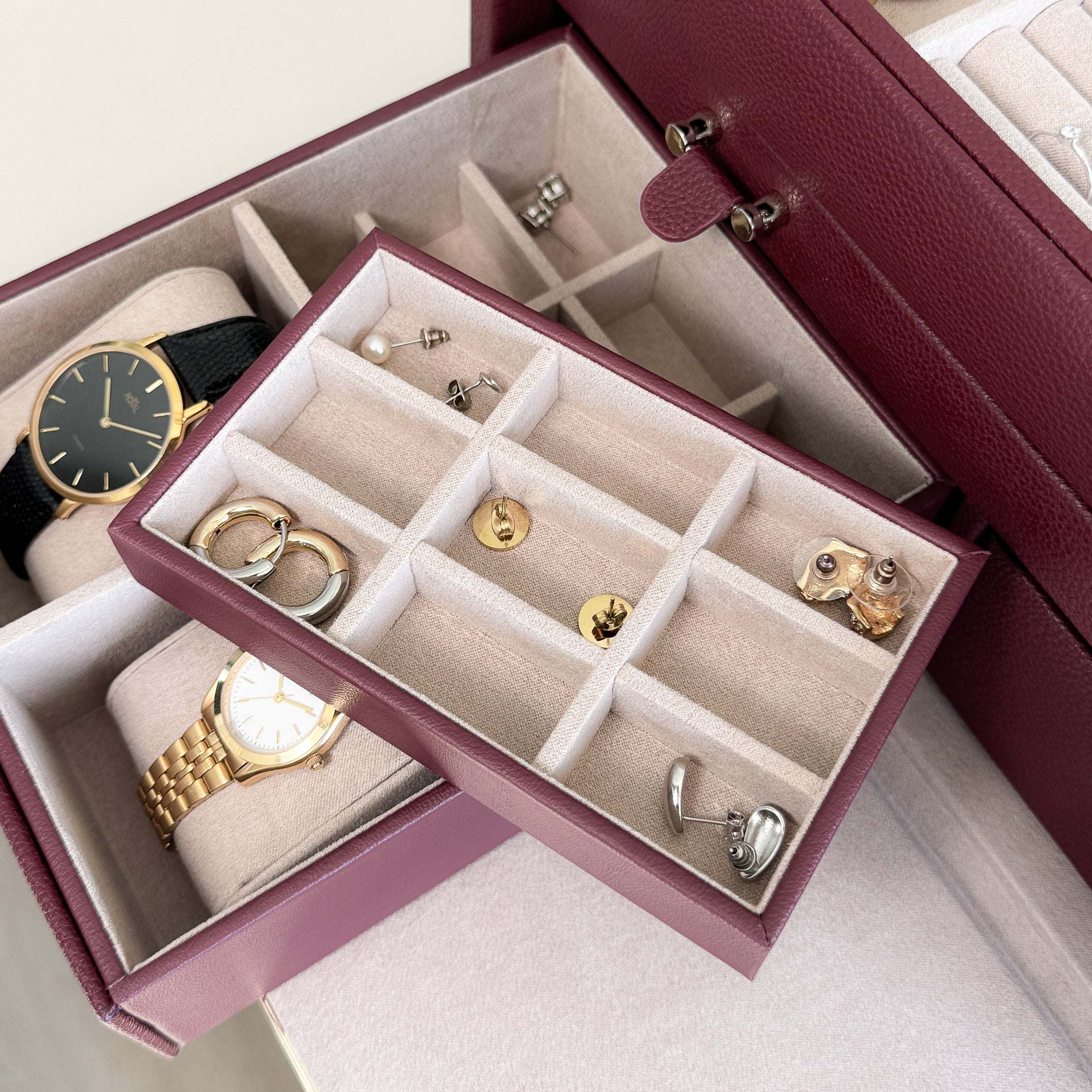 Grande boîte à bijoux en cuir bordeaux de la collection Vitoria. Vue ouverte, remplie de bijoux et montres