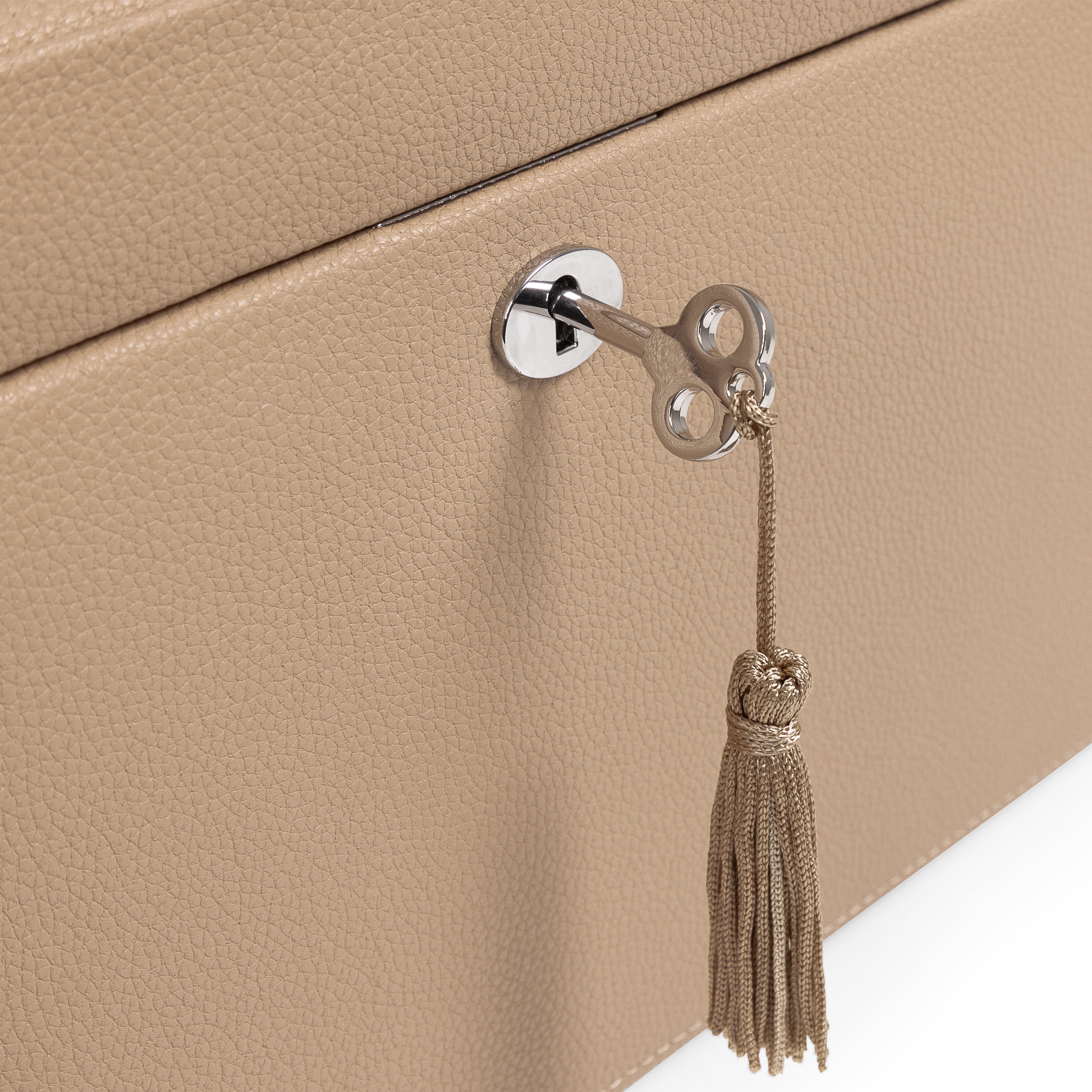 Grande boîte à bijoux en cuir cappuccino de la collection Vitoria. Zoom sur le fermoir argenté et la clé avec son pompon. Fond blanc