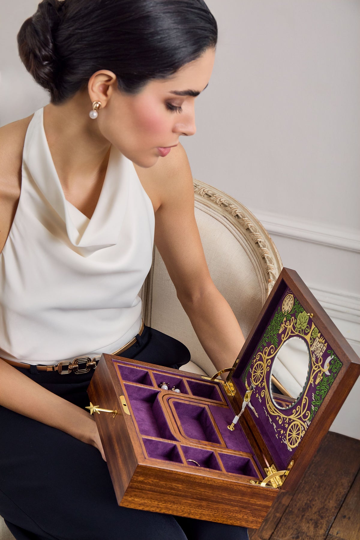 Femme élégante contemplant une boîte à bijoux en bois ouverte avec miroir, compartiments et intérieur en velours violet, issue de la collection Ballet de WOLF 1834.