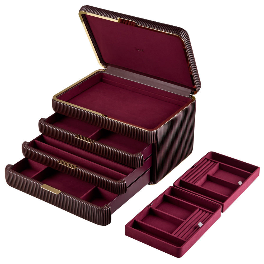 Armoire à bijoux couleur bordeaux de la collection Bella de la manufacture Wolf 1834. Vue de transverse, la boîte à bijoux est ouverte, les tiroirs sont tirés, et les compartiments intérieurs du coffret sont posés à côté de la boîte
