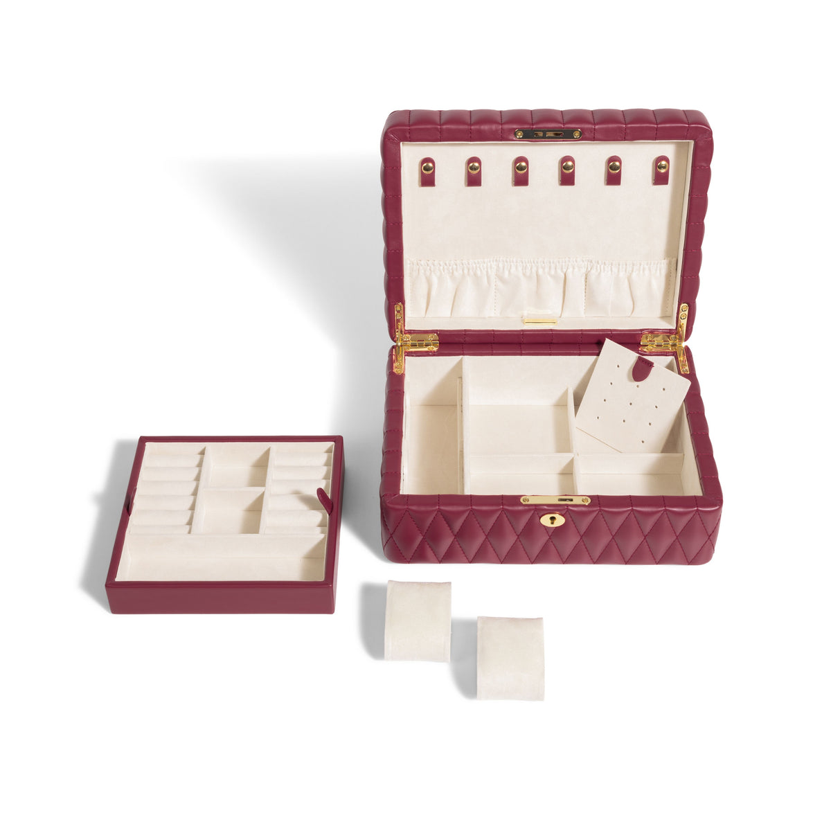 Boîte à bijoux matelassé Saphira bordeaux. Vue de face haut, la boîte à bijoux est ouverte et vide, et le compartiment amovible intérieur est posé à côté de la boîte, ainsi que les coussins à montre