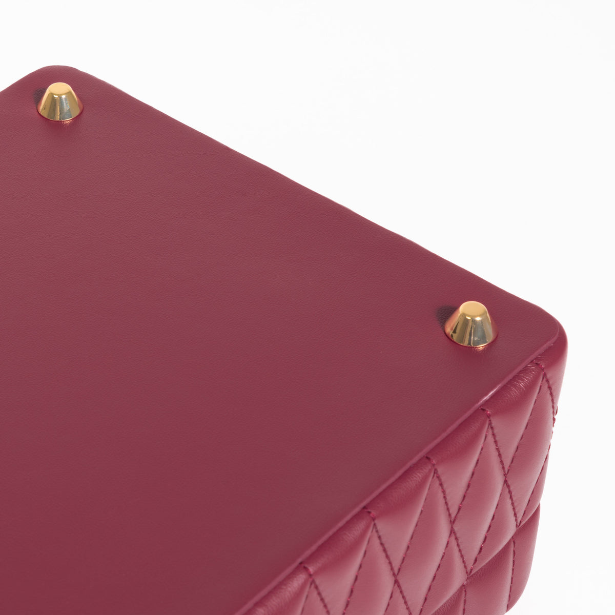 Boîte à bijoux matelassé Saphira bordeaux. Zoom sur les pieds dorés de support de la boîte