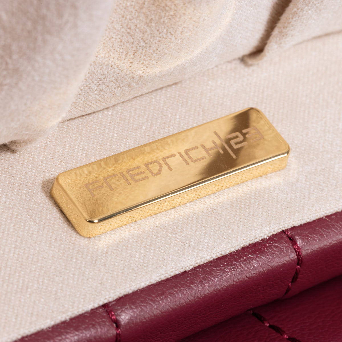 Boîte à bijoux matelassé Saphira bordeaux. Zoom sur le logo fournisseur