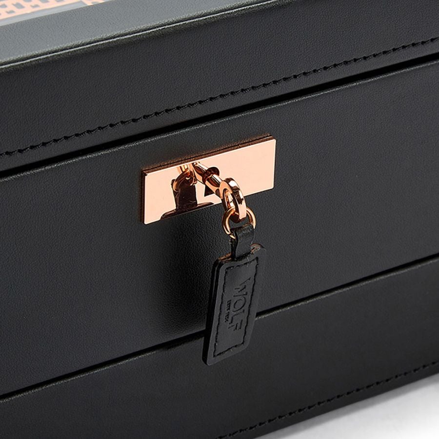 Gros plan sur la serrure cuivrée et le porte-clé en cuir de la boîte à montres Wolf Axis