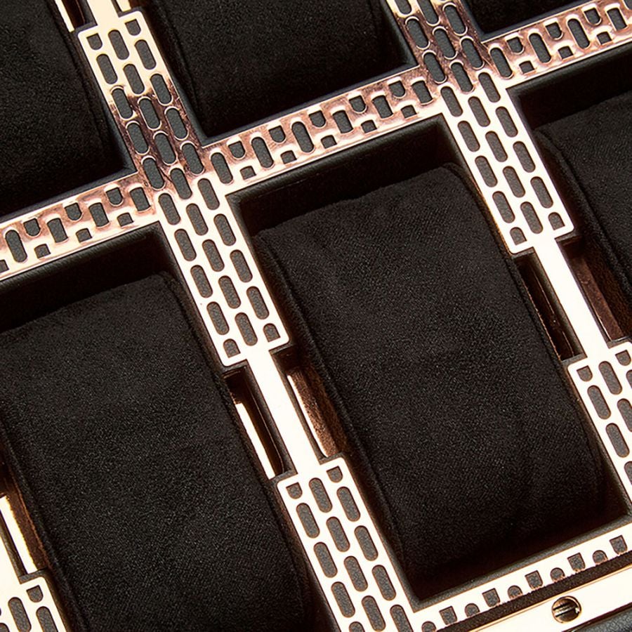Gros plan sur la grille cuivrée décorative et les coussins noirs de la boîte à montres Wolf Axis