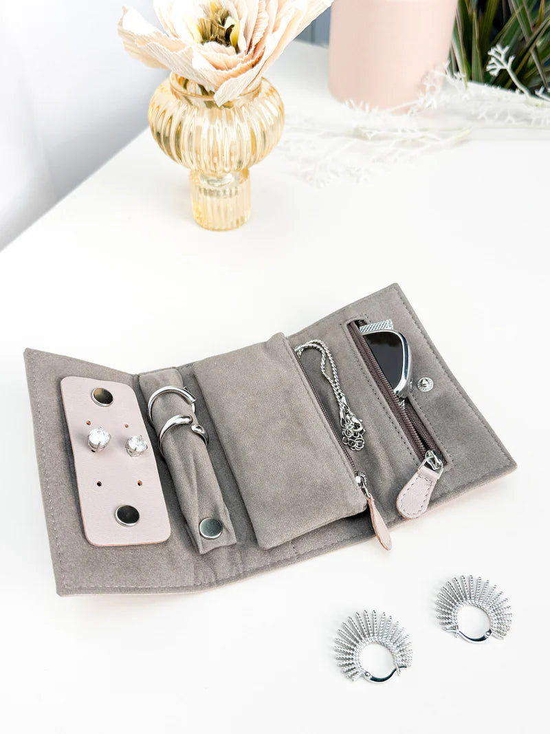 Pochette en cuir véritable Sienna, cuir véritable, beige cappuccino ouvert sur une table, avec des bijoux dedans et à côté d'autres accessoires