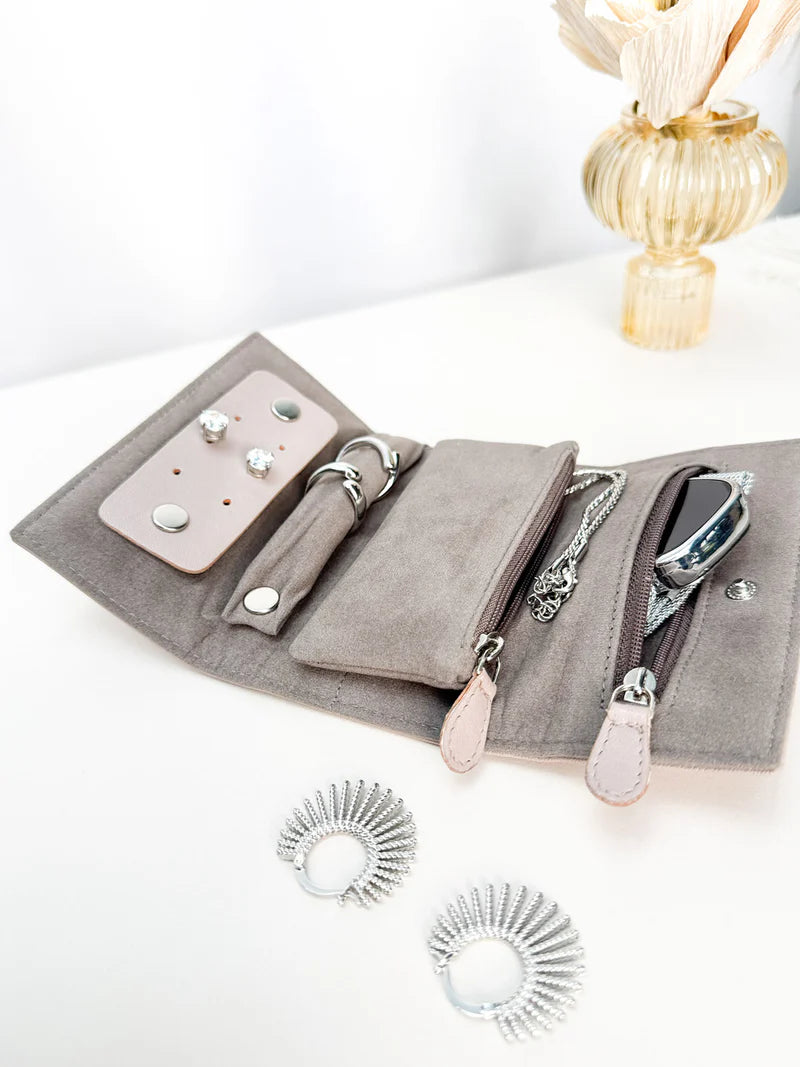 Pochette en cuir véritable Sienna, cuir véritable, beige cappuccino ouvert sur une table avec des bijoux dedans