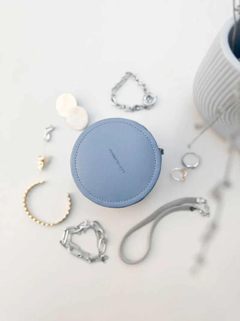 Mini boite à bijoux ronde en cuir véritable Sienna, bleu clair, vue fermée et entourée de bijoux