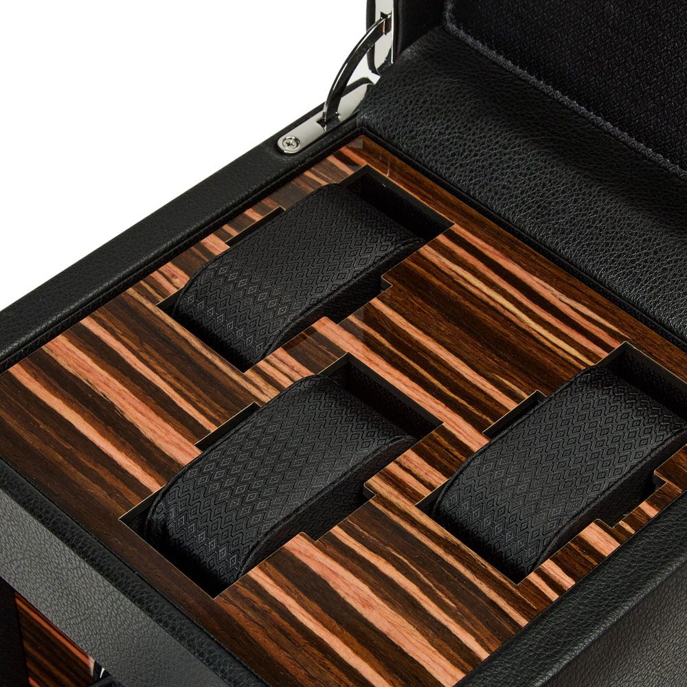 Gros plan sur l’intérieur du remontoir WOLF avec finition bois d’ébène et trois supports à montres en cuir texturé noir